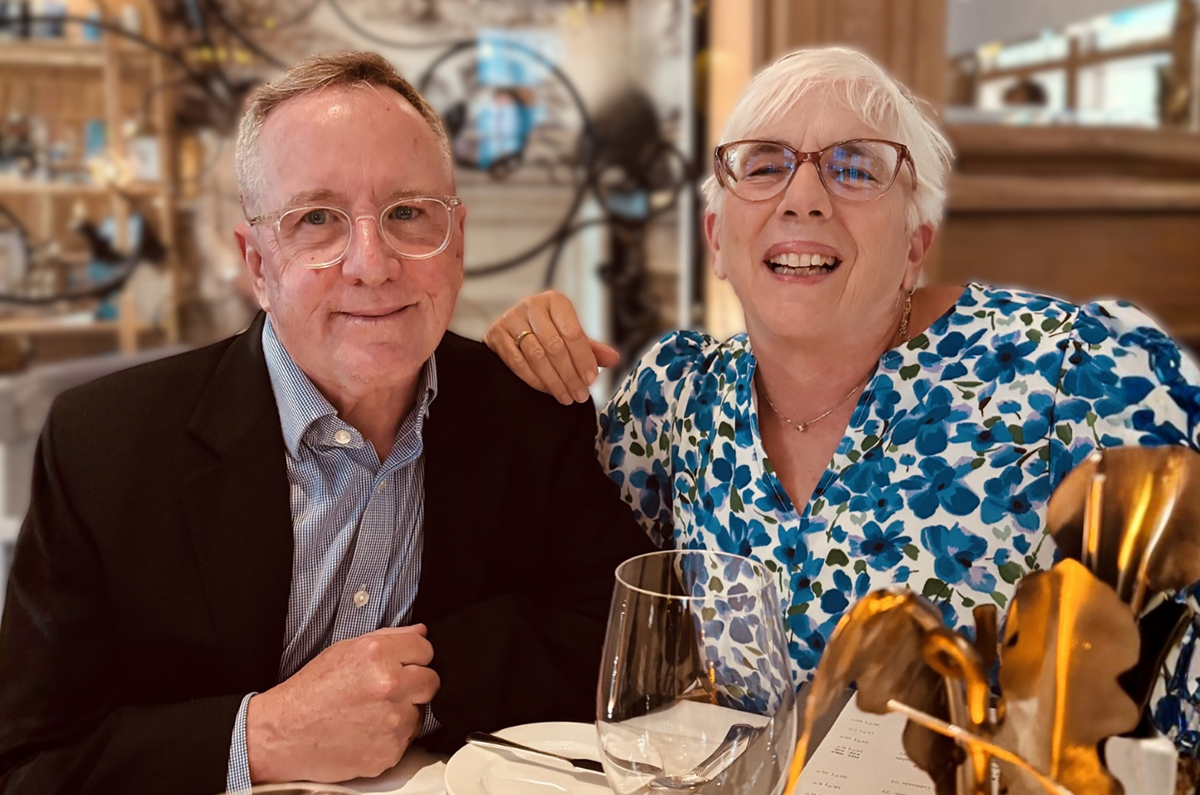Photo of Andy Corrigan and Trish Del Nero at restaurant, they sit at a table looking into the camera
