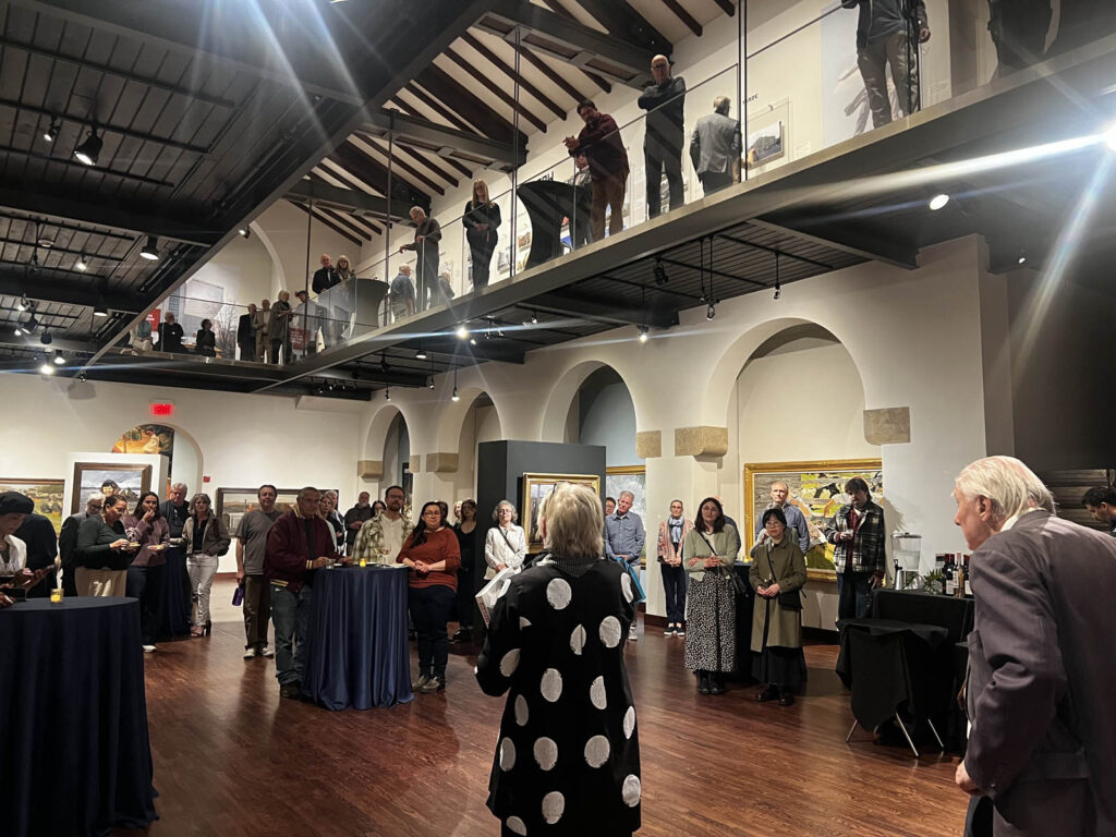 Photographer and author, William Brumfield, stands in the far right before a crowd at&nbsp;Avant-garde Architecture of the Soviet Era: Photography by William Brumfield&nbsp;exhibit at&nbsp;The Museum of Russian Art.