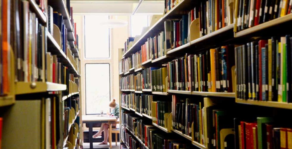 An aisle between the book sehlves in the Howard-Tilton Library