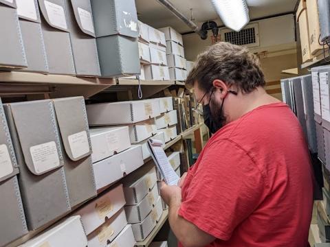 Matthew Folse conducting a collection survey in the TUSC stacks.
