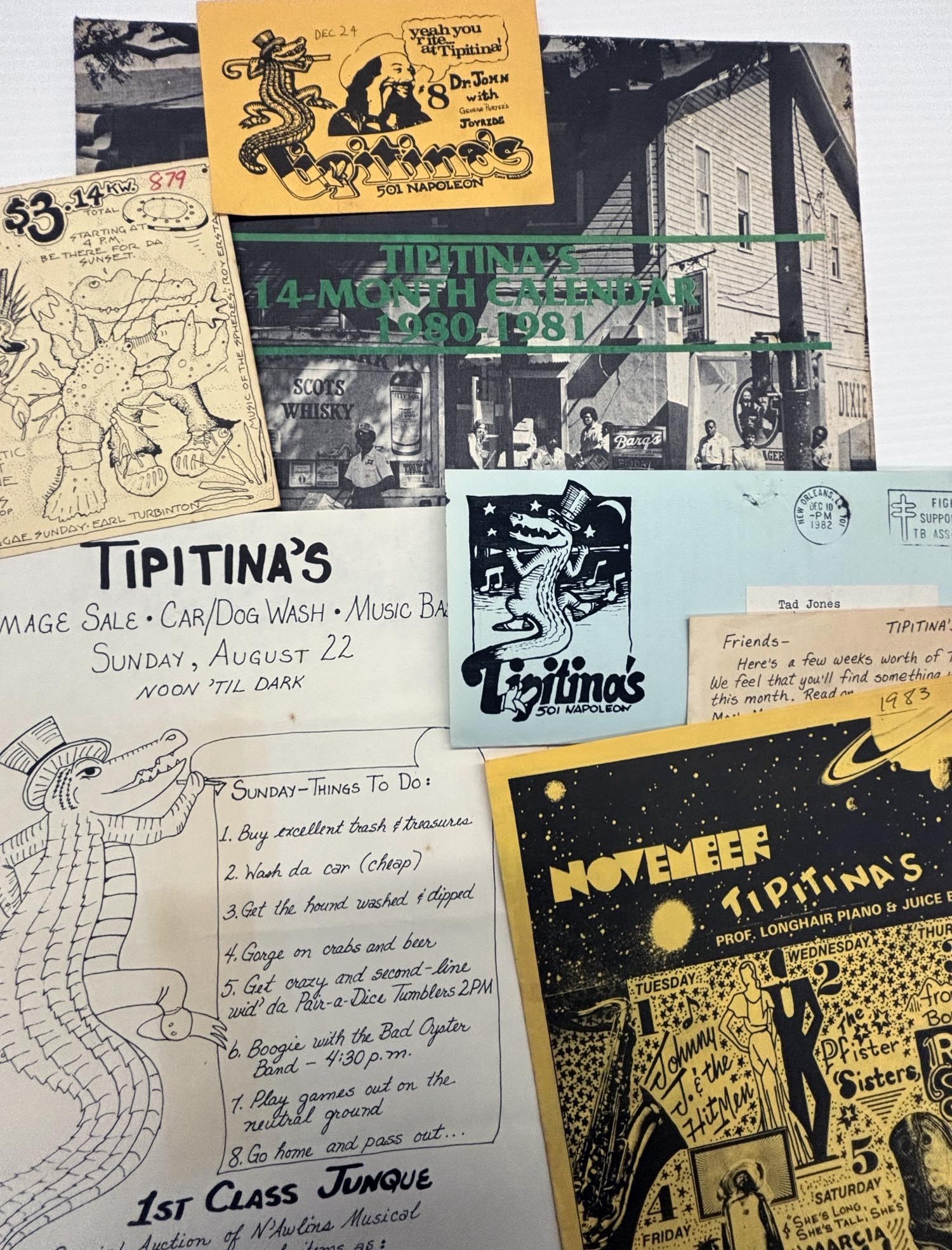 A flat-lay collage of vintage Tipitina’s music venue ephemera from the late 1970s–early 1980s, including illustrated flyers, postcards, and a 1980–1981 calendar. The items feature hand-drawn alligators, musicians, and bold typography in black, yellow, and blue, with readable text such as “Tipitina’s, 501 Napoleon,” event listings, benefit notices, and show promotions. The overall look is worn and nostalgic, evoking New Orleans music culture and grassroots concert promotion.