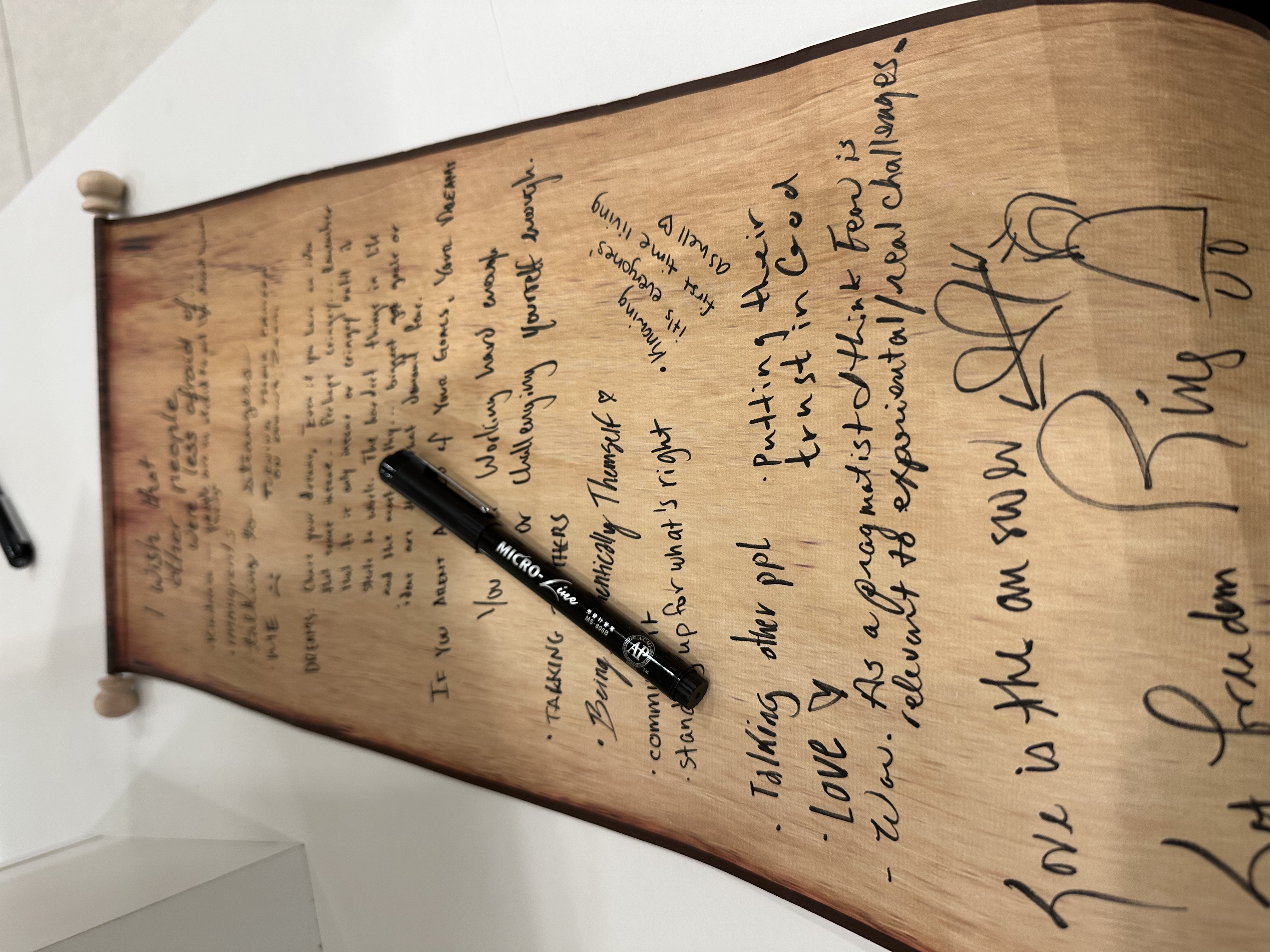 Scroll on white shelf, with many handwritten notes by different people writing what they wish other people were less afraid of